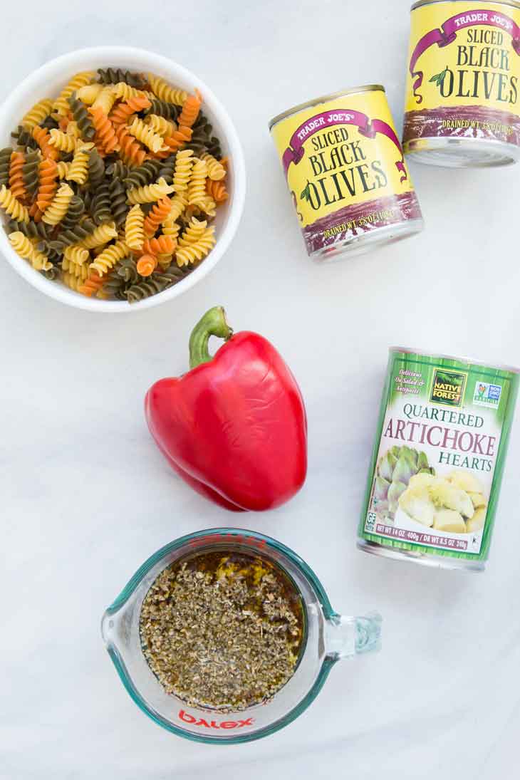 ingredienserne til en let pastasalatopskrift. Pasta, peber, dressing, artiskok og oliven!