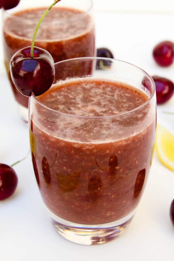 A close up of cherry chia fresca garnished with cherries