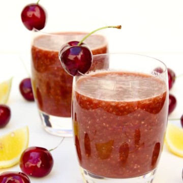 Two glasses of cherry chia fresca garnished with cherries
