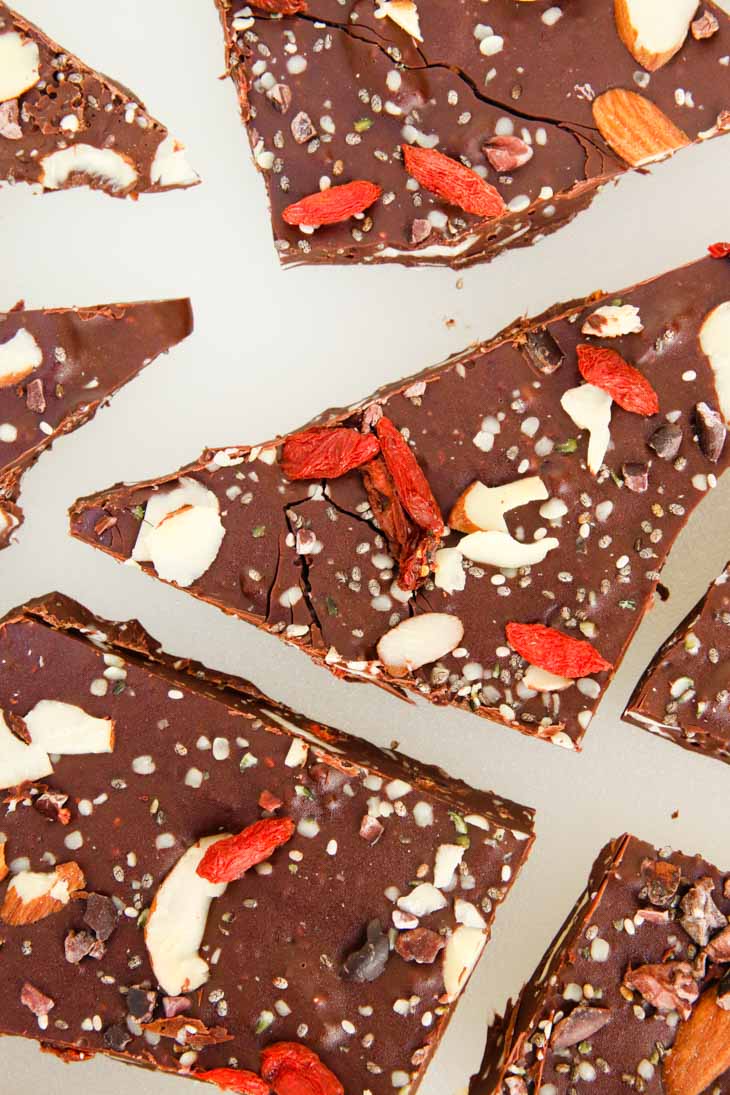 An overhead shot of dark chocolate bark covered in nuts and seeds