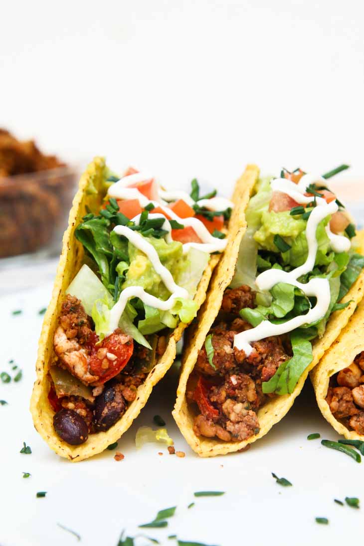 A side close-up photograph of two vegan black bean tofu tacos garnished with cilantro.