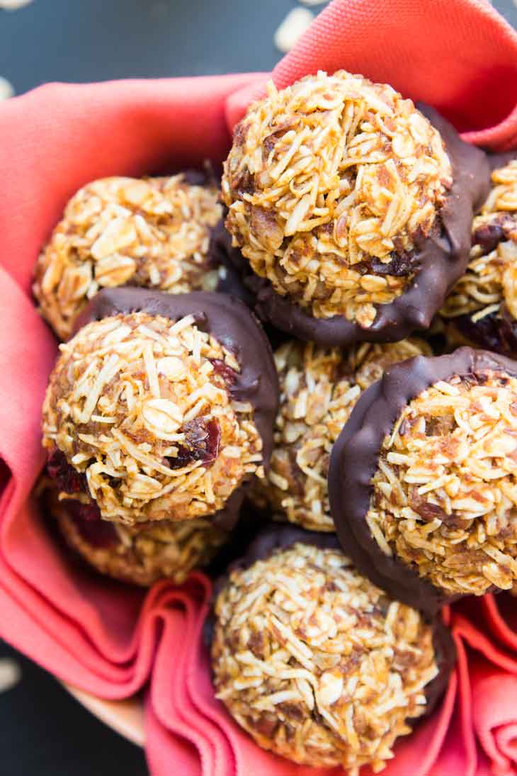 Best vegan meal on VG in 2017. Overhead photograph of no-bake pumpkin pecan coconut bites dipped in chocolate, sitting in a bowl on top of a red napkin. 