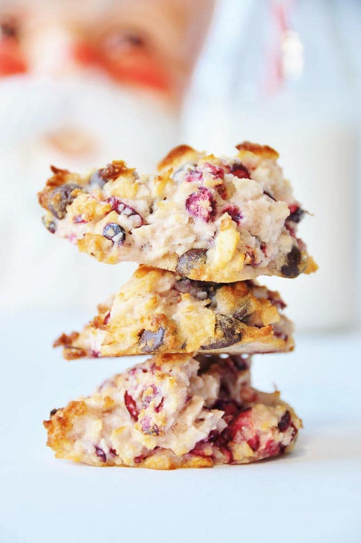 A stack of three cranberry coconut chocolate macaroons sitting on a white tray. 
