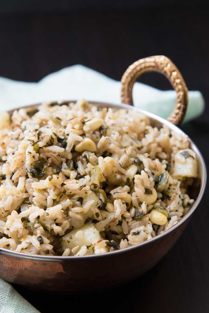 Quick indian pulao rice recipe with potatoes, spinach, and corn in a copper serving bowl.