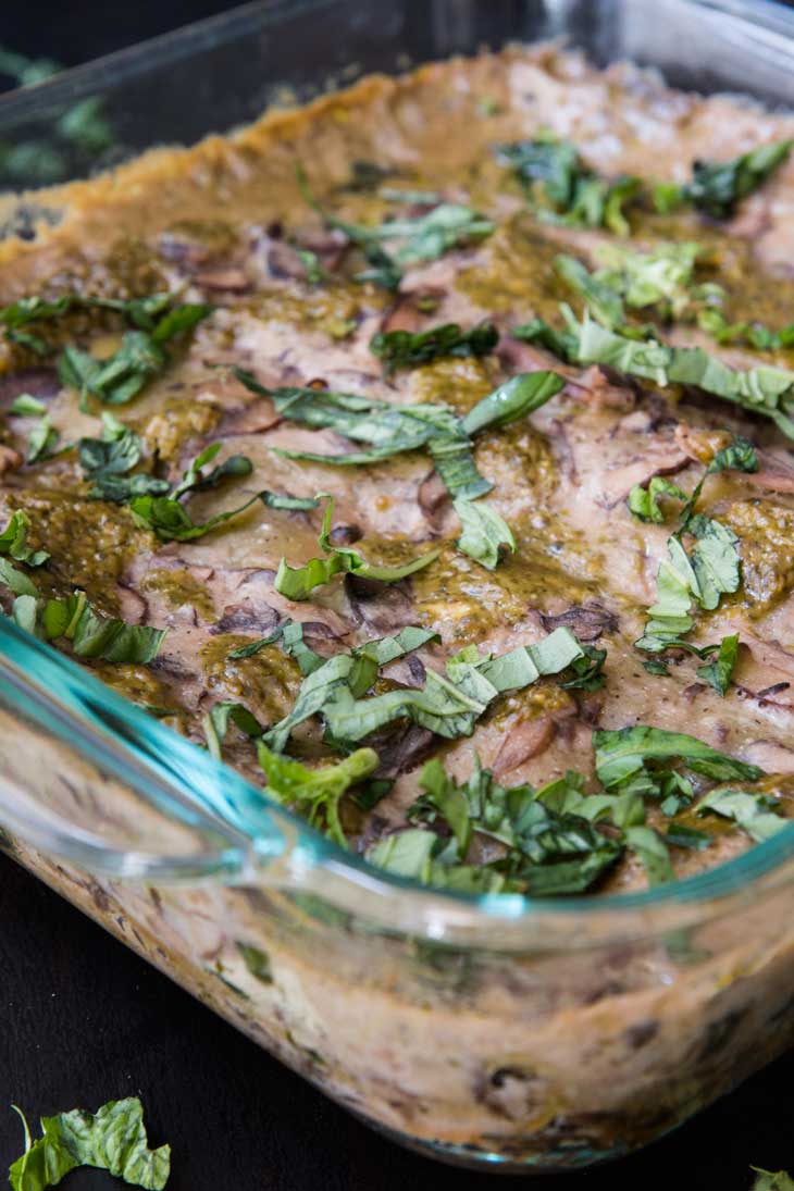 A close-up photograph of a 8x8 glass tray with vegan spinach mushroom lasagna. 