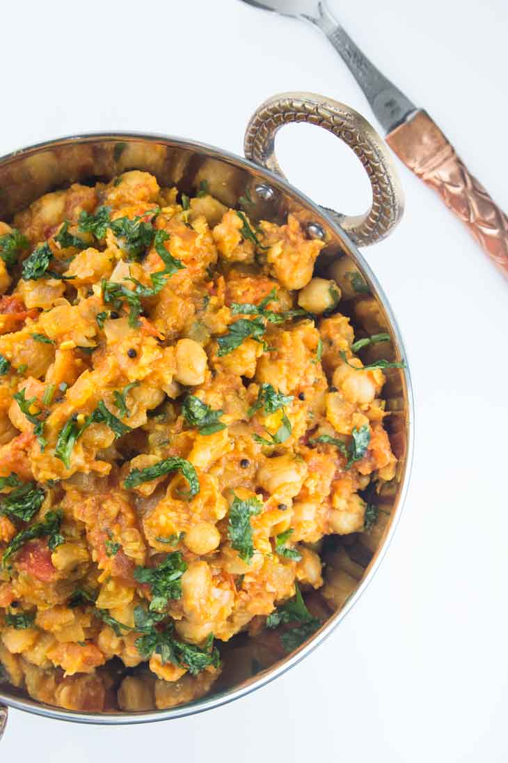 Seventh best vegan meal on VG in 2017. An overhead photograph of chole masala (chickpea curry) served in a copper bowl with handles. 