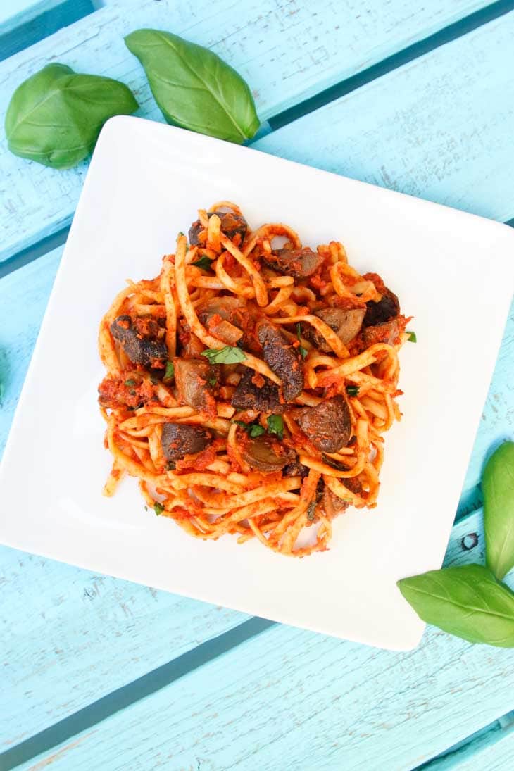 An overhead shot of roasted mushrooms with linguine and tomato basil butter