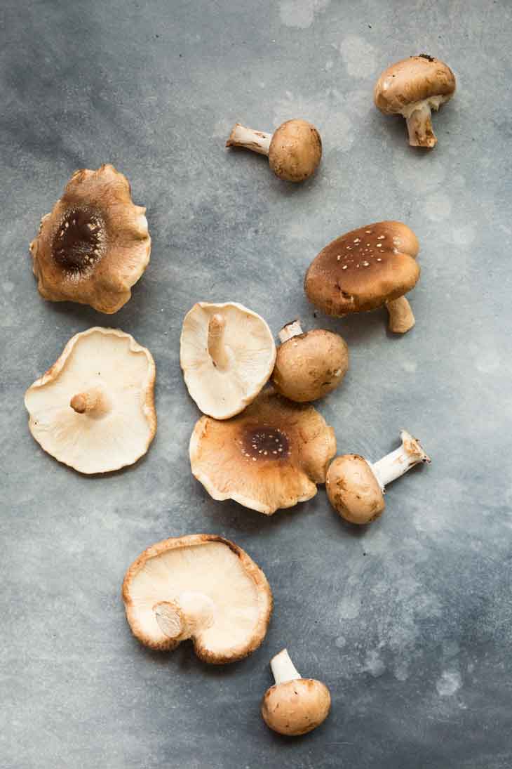 An overhead photograph of raw shiitake and portobello mushrooms for a bbq sandwich.