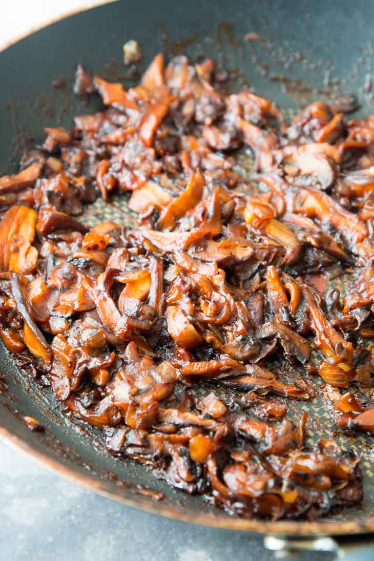 A thick and sticky bbq sauce and mushroom mixture cooking on a pan, for a bbq sandwich recipe.