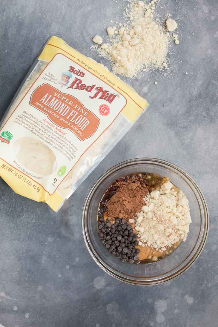 Overhead photograph of bobs red mill almond flour and a mixing bowl with all the ingredients for cookie dough bites.