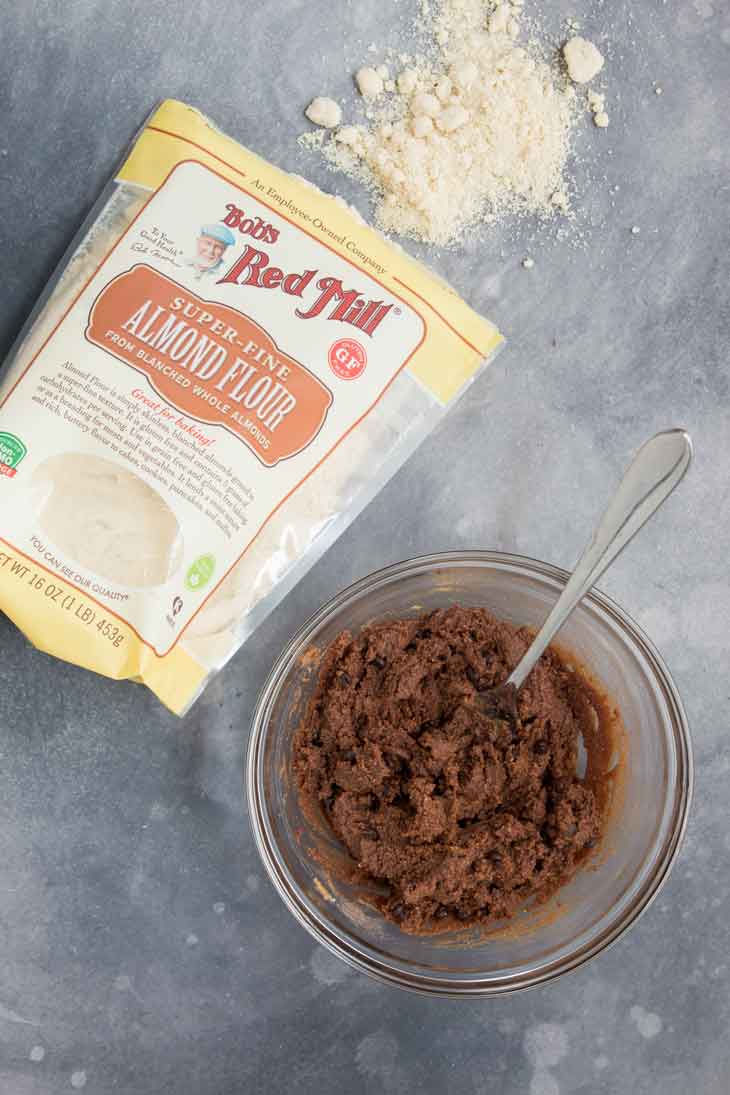 A mixing bowl with batter for the cookie dough bites, almond flour bag on the side.