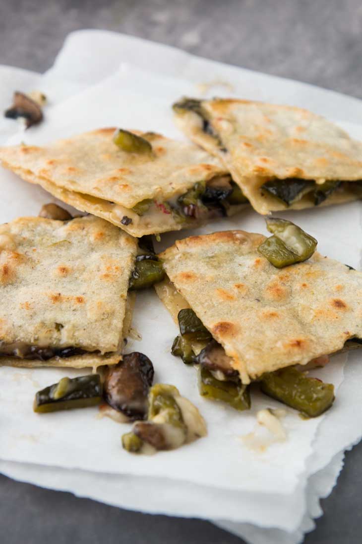 A side closeup of vegan quesadilla pieces stuffed with poblano peppers and mushrooms.